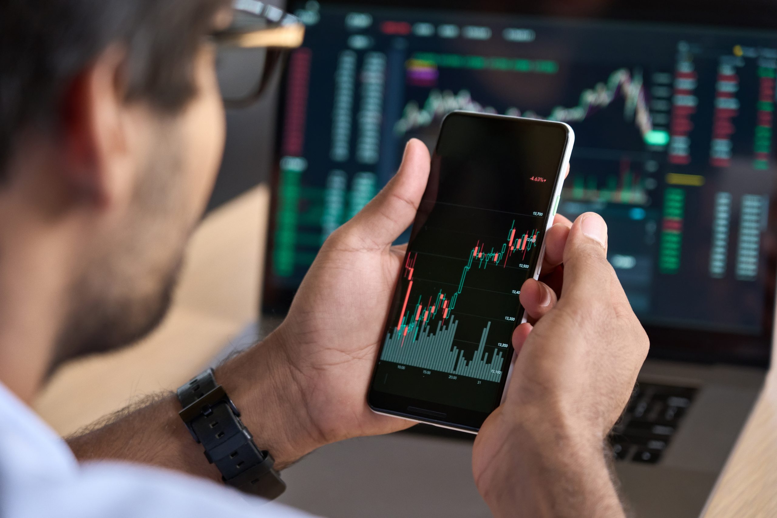 Homem analisando gráficos em app de performance dentro de uma comunidade high ticket