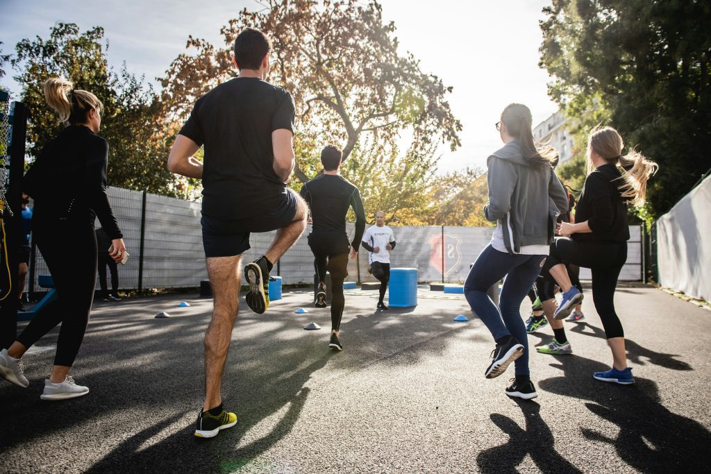 Grupo de alunos treinando ao ar livre, mostrando como vender mais plano de treino com apoio de uma comunidade fitness engajada